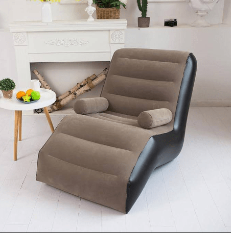 Brown inflatable chair in a room with a fireplace and small table.