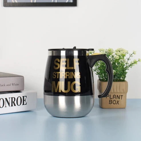 Black self-stirring mug with gold text on a light blue surface 