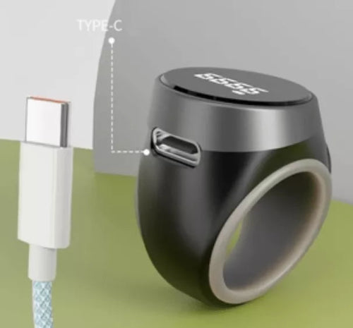 Black ring-shaped device with USB-C connector on a green surface