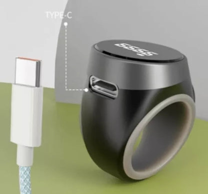 Black ring-shaped device with USB-C connector on a green surface