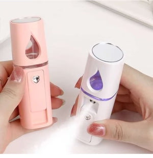 Two handheld devices, one pink and one white with a purple droplet symbol, held by hands on a light background.