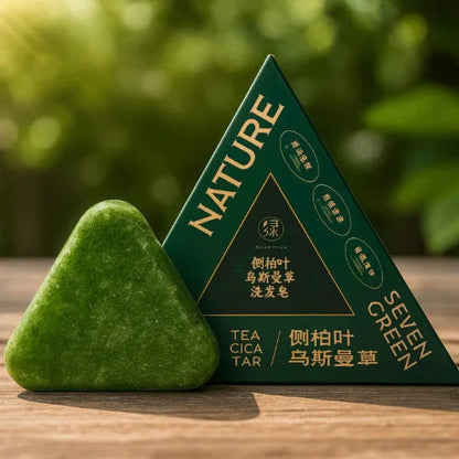 Green triangular soap and packaging on a wooden surface with a blurred green background