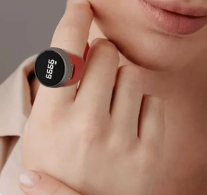 Close-up of a hand wearing a red digital fitness tracker